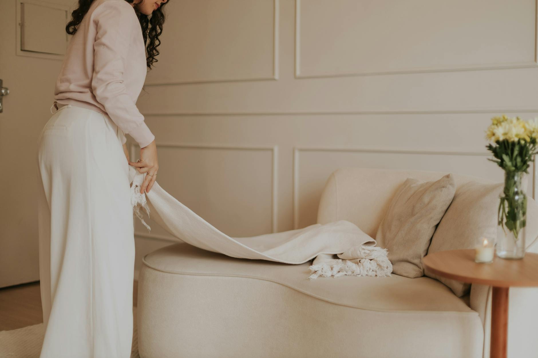 Jasny, minimalistyczny salon z kobiecymi, przytulnymi akcentami