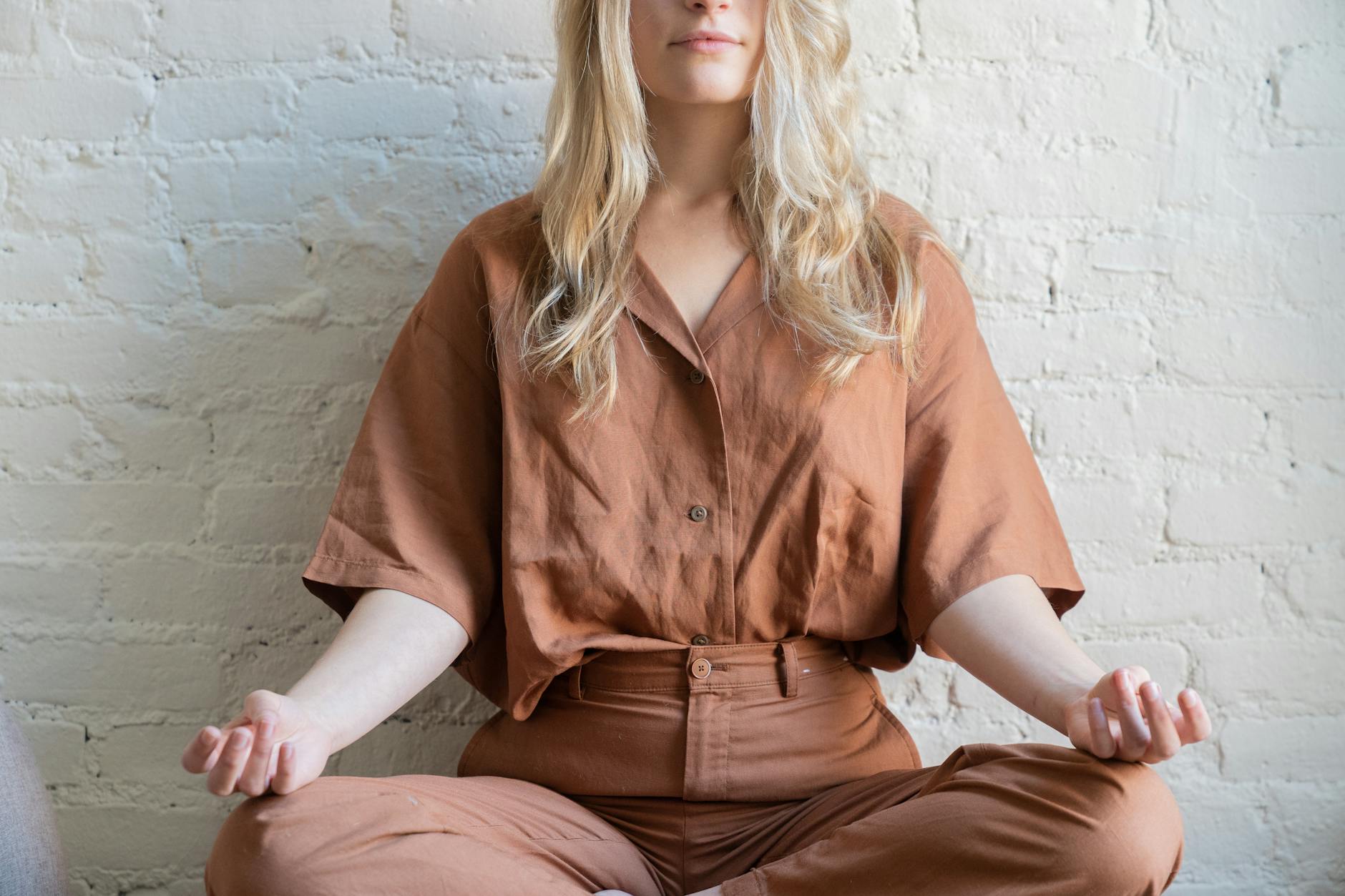 Kobieta medytuje w domu, skupiona na oddechu i uważności