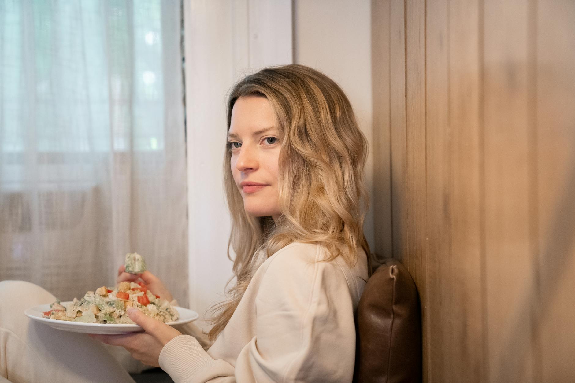 Blondynka je spokojnie zdrową sałatkę przy stole w domowym zaciszu