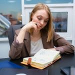 Zamyslona bizneswoman planująca spokojnie swój harmonogram przy biurku