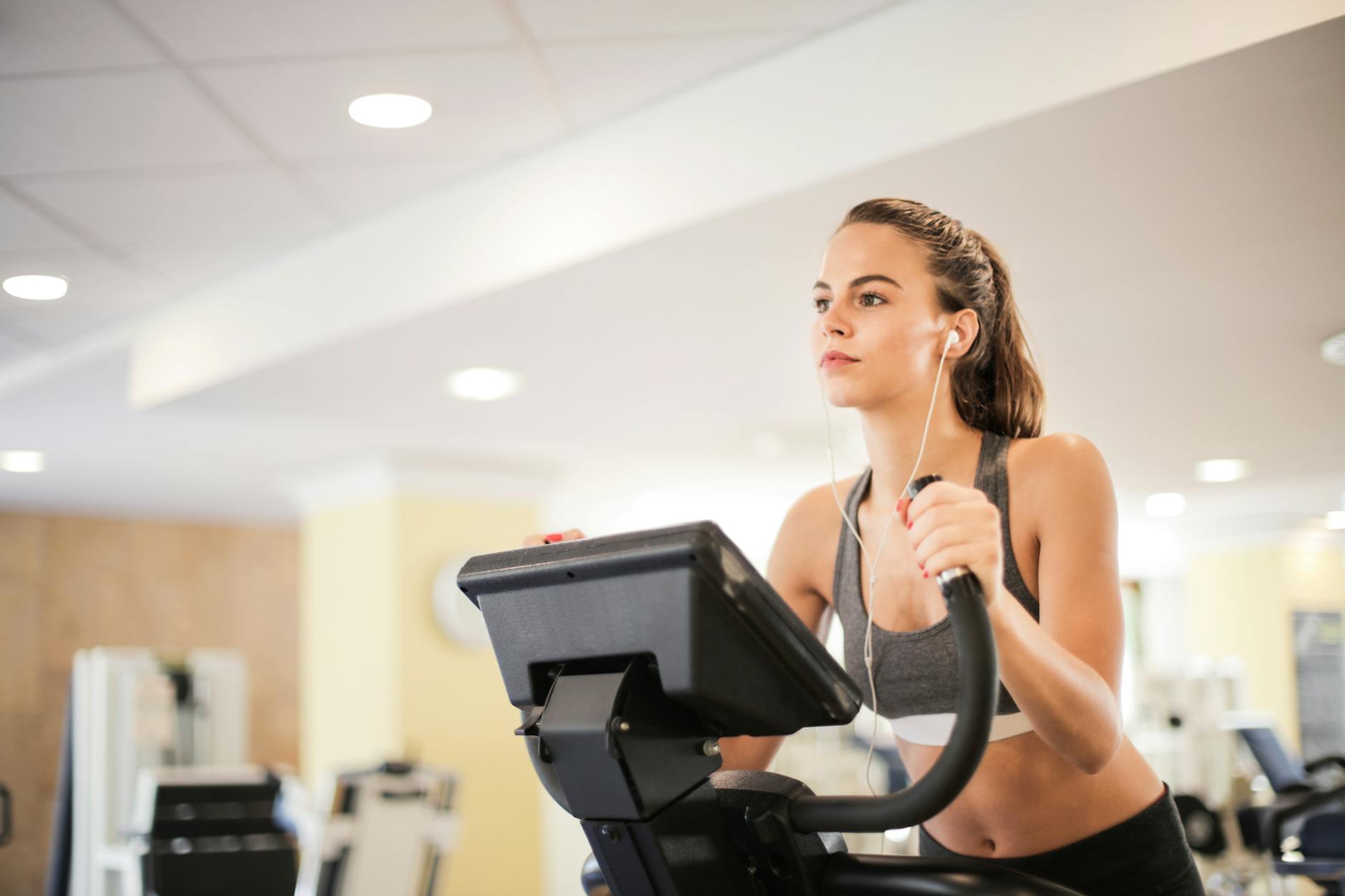 Kobieta na siłowni w Piłe ćwiczy cardio na orbitreku