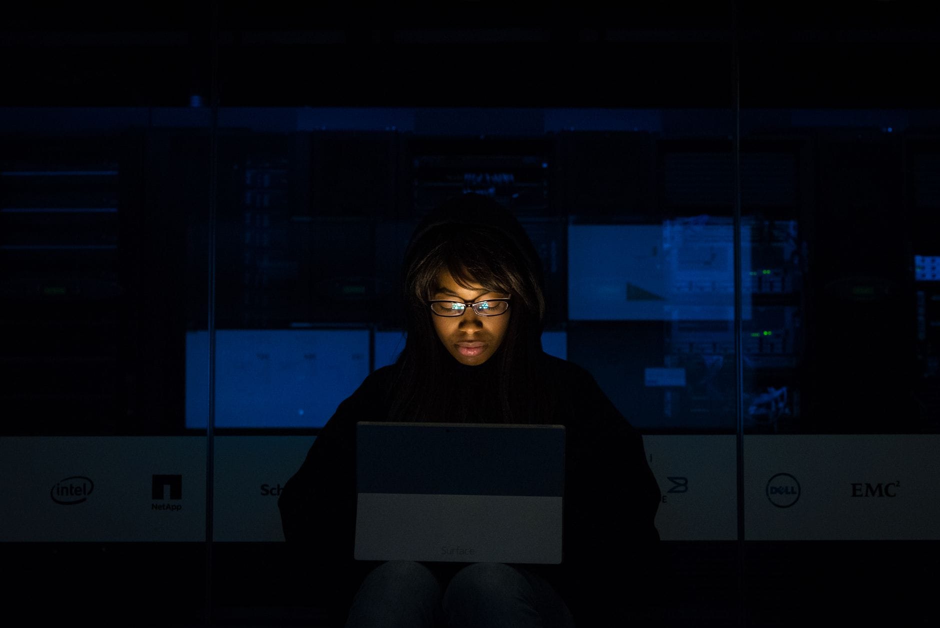 Kobieta programistka przy laptopie w ciemnym centrum danych