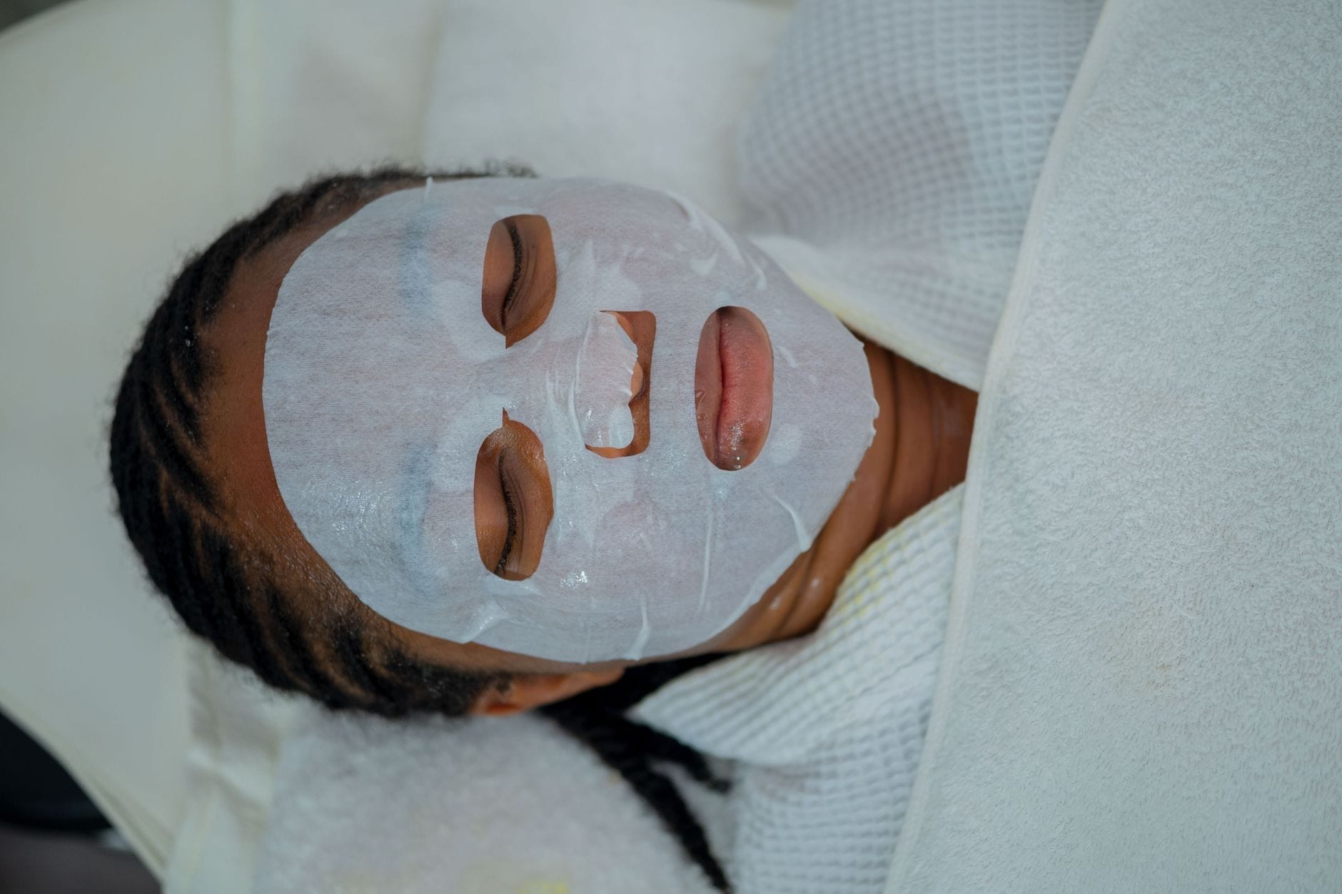 Kobieta podczas relaksującego zabiegu maseczką na twarz w spa