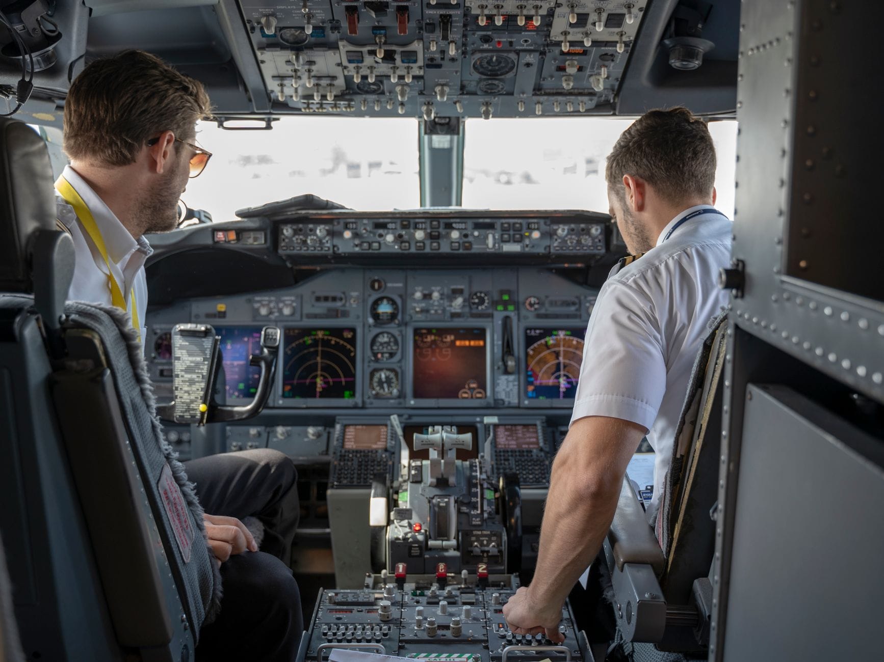 Dwóch pilotów w kokpicie samolotu pasażerskiego przy przyrządach