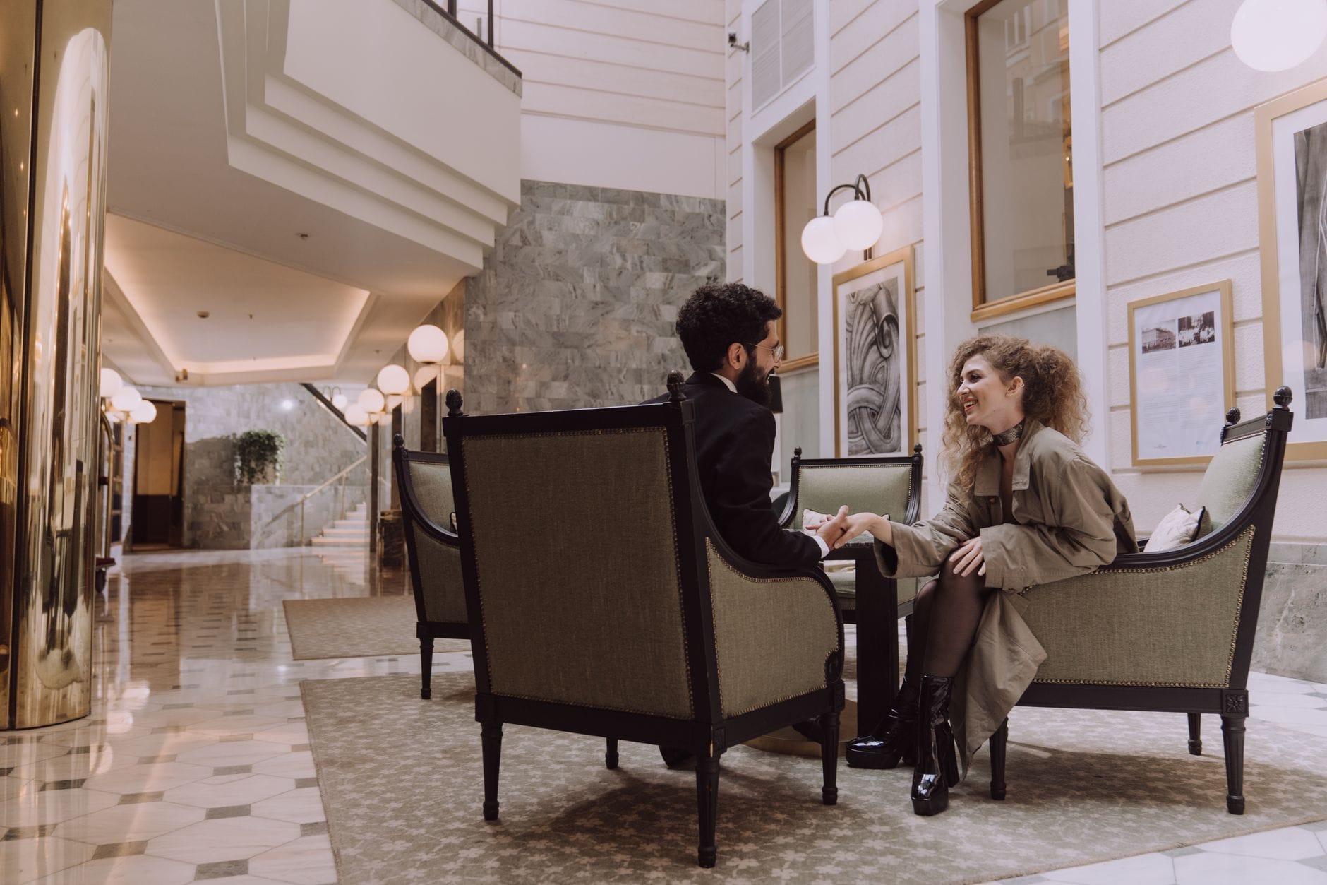 Elegancka para siedząca w luksusowym lobby hotelu