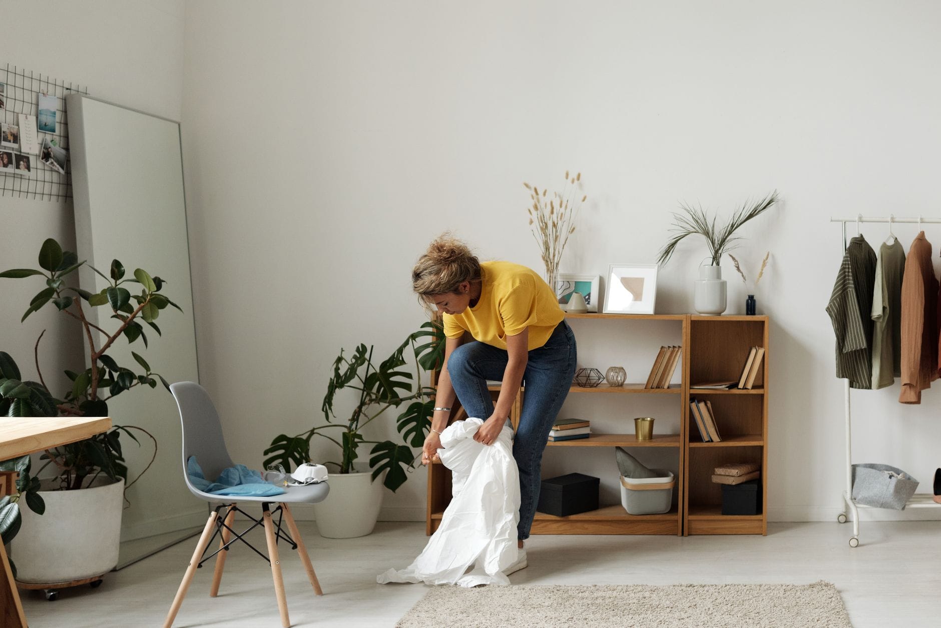 Kobieta porządkuje minimalistyczny salon z naturalnymi dodatkami